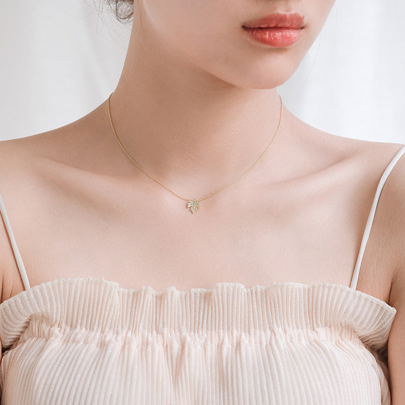 Necklace with a small pendant worn by a person against a neutral background
